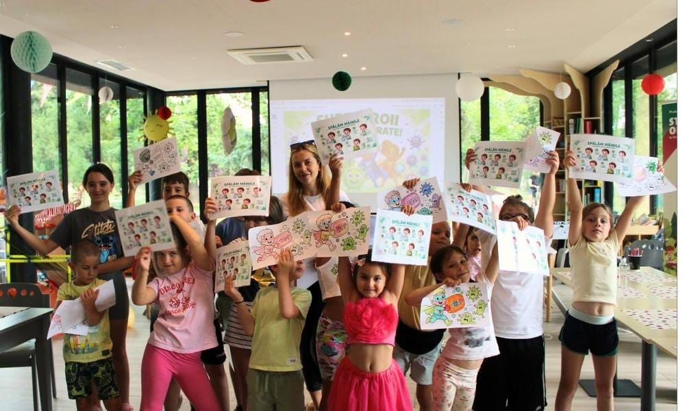 Copiii participanți la atelierul de prevenție medicală arată fișele „Spălăm mâinile”, la Nest, în Parcul Copiilor din Timișoara